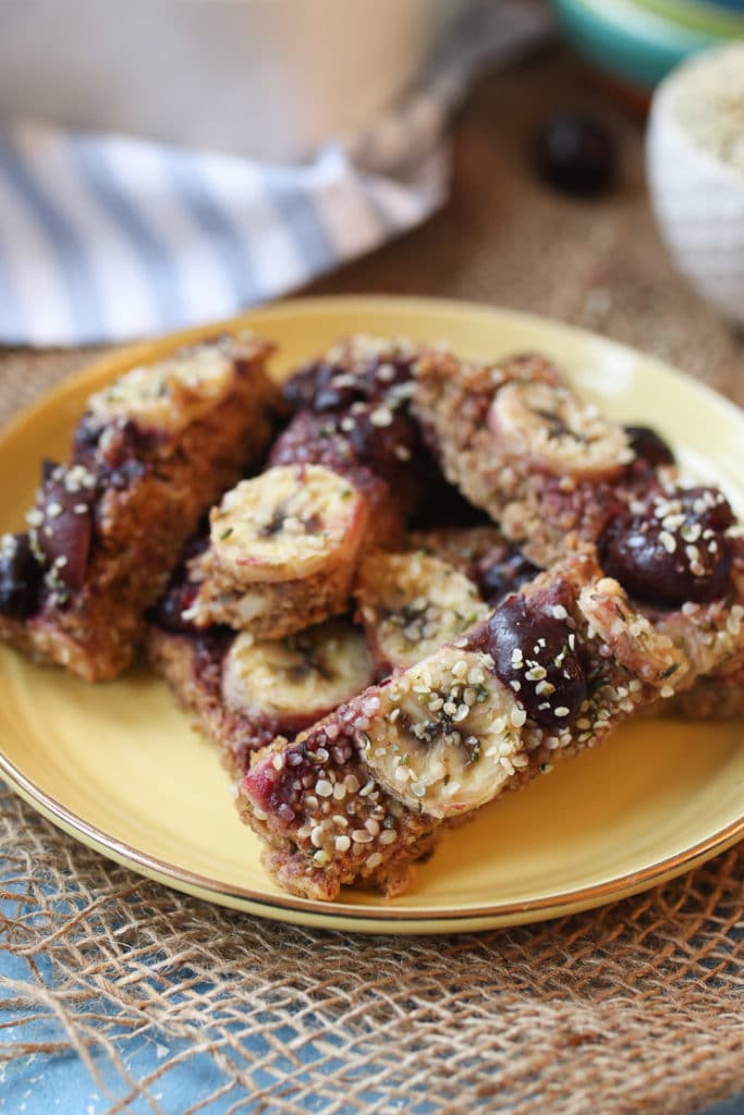 Close up of cherry almond baked oatmeal baby finger on a yellow plate.
