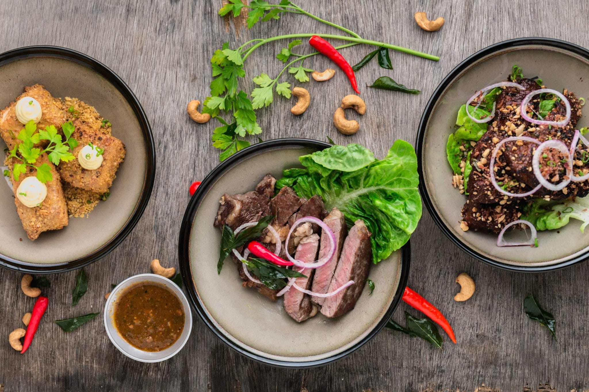 birds eye view of grey bowls filled with meat and vegetables