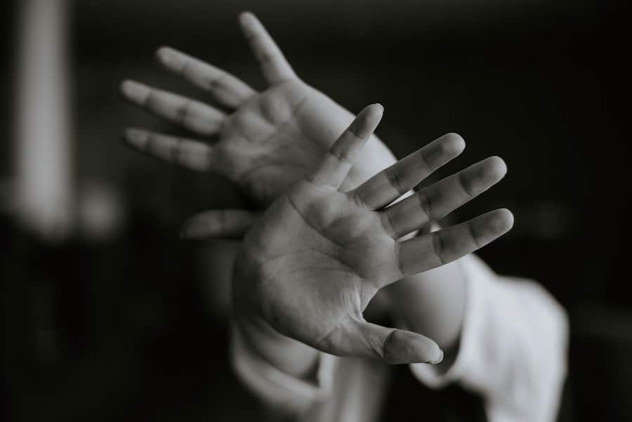 A close up of two hands waving in black and white referring to experiencing anxiety while pregnant.