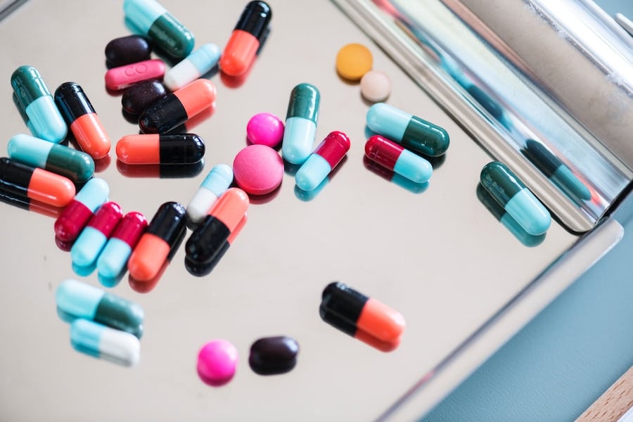 An assortment of colourful pills on a metal tray referring to taking medication for anxiety while pregnant.
