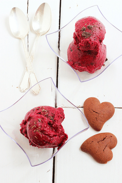birds eye view of vegan berry and chocolate sorbet in two clear bowls next to heart shaped cookies