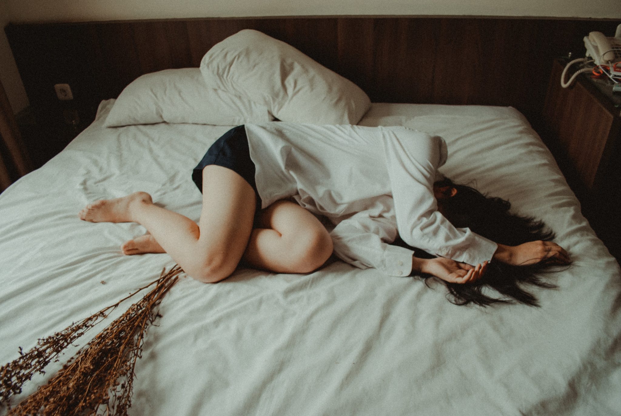 woman in white shirt on bed 