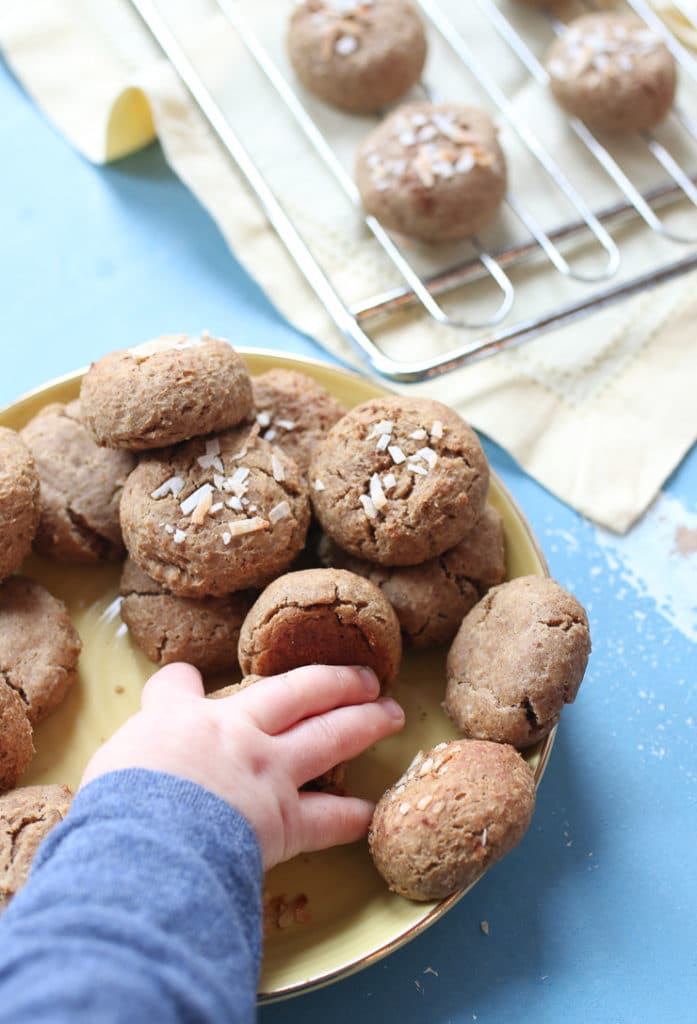 Baby's hand grabbing chickpea peanut butter baby biscuits.