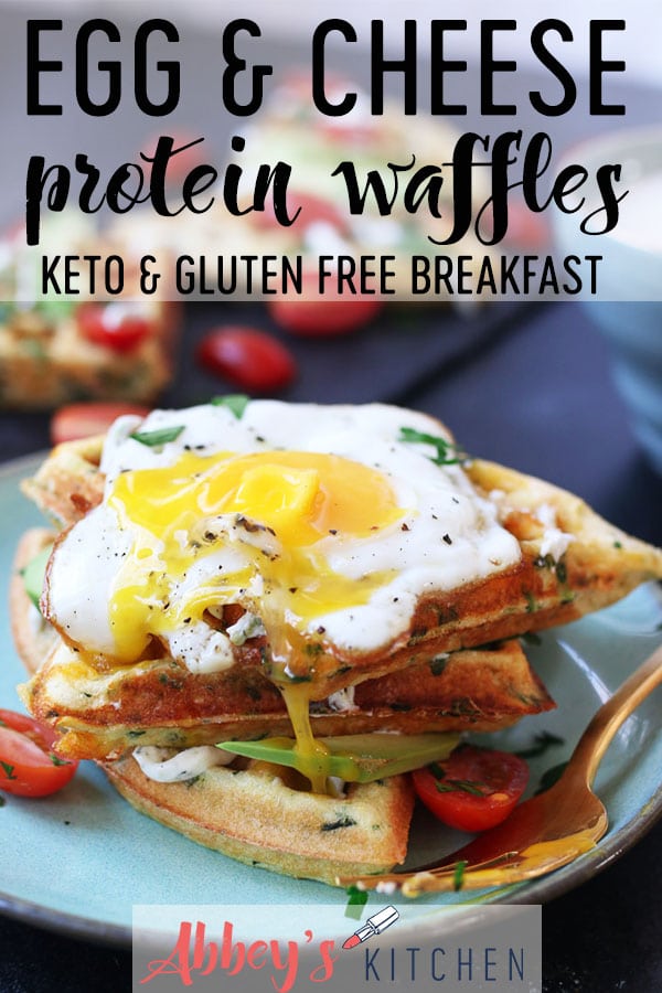 Egg and cheese savory protein waffles piled on a turquoise plate topped with a fried egg.