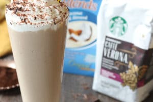 Tiramisu vegan milkshake in a tall glass with whip cream and a straw using Starbucks coffee and coconut milk.
