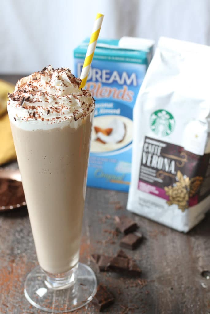 Tiramisu vegan milkshake in a tall glass with whip cream and a straw using Starbucks coffee and coconut milk.