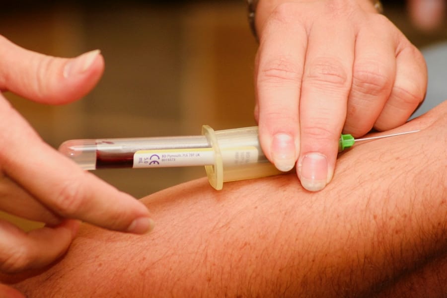 Taking a blood sample from a person's arm.