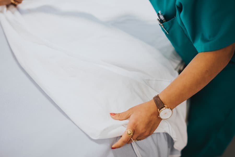 Healthy practitioner folding white sheets.