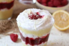 Vegan lemon mousse parfait layered with raspberry chia jam in a glass.