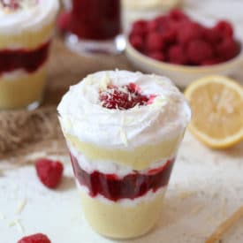 Vegan lemon mousse parfait layered with raspberry chia jam in a glass.