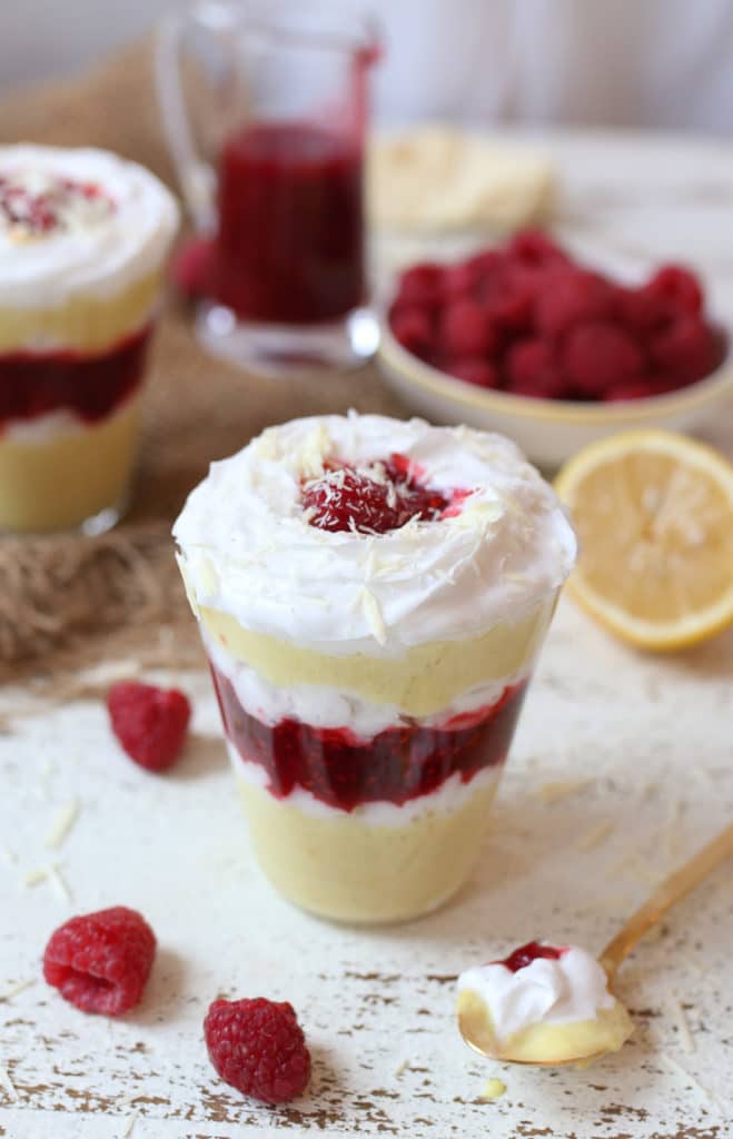 Vegan lemon mousse parfait layered with raspberry chia jam in a glass.