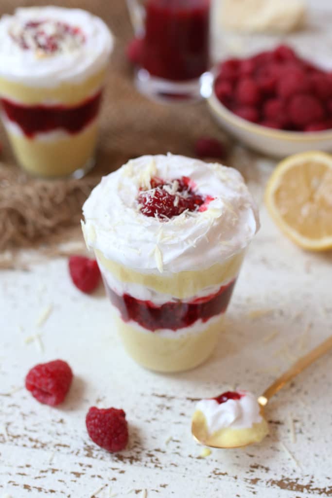 Vegan lemon mousse parfait layered with raspberry chia jam in a glass.