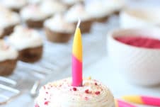 Mini vegan cupcake with one lit candle in the middle.