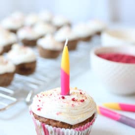 Mini vegan cupcake with one lit candle in the middle.