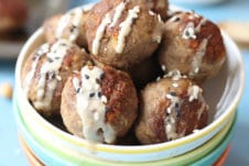 Hummus baby meatballs in a bowl with tahini drizzle and sesame seeds.