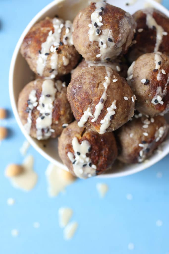 Hummus baby meatballs in a bowl with tahini drizzle.