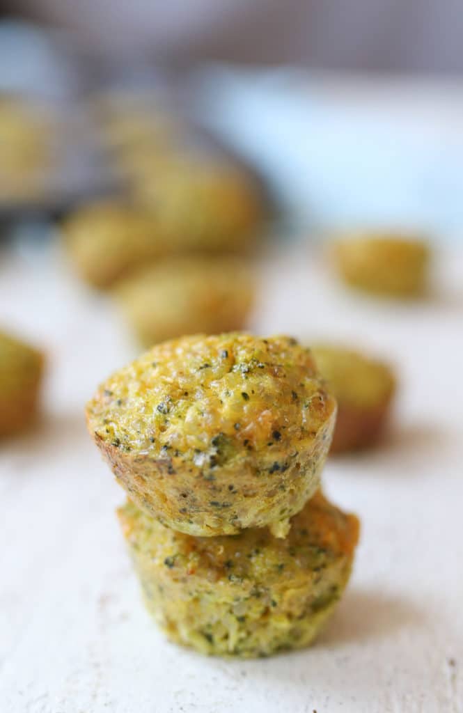Two mini broccoli and cheese egg muffins piled on top of each other.