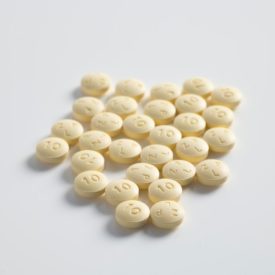 A bunch of small round pills on a white surface.