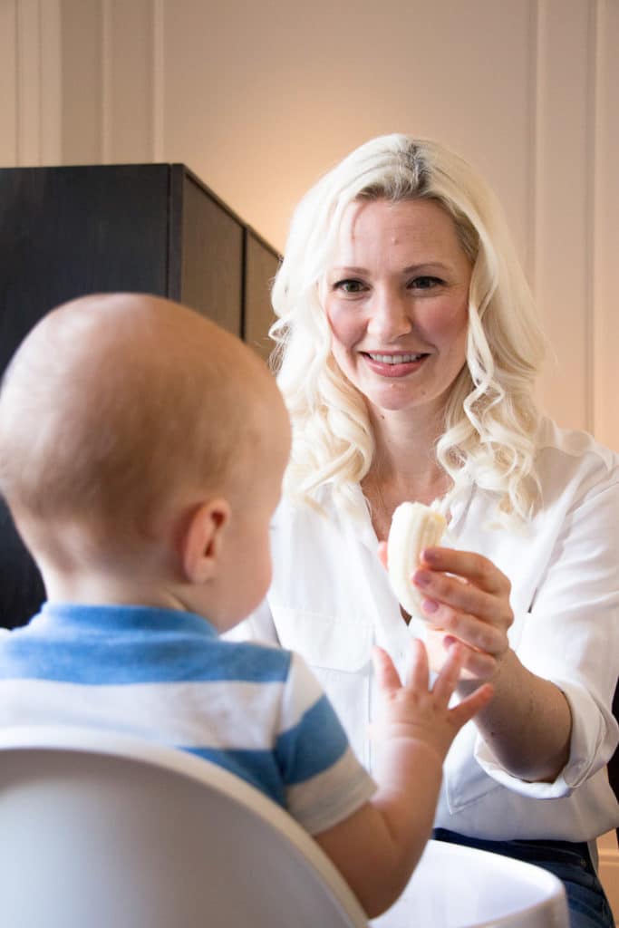 Women feeding her baby in a high chair.