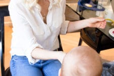 Women feeding her baby in a high chair