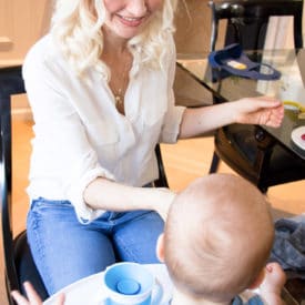 Women feeding her baby in a high chair