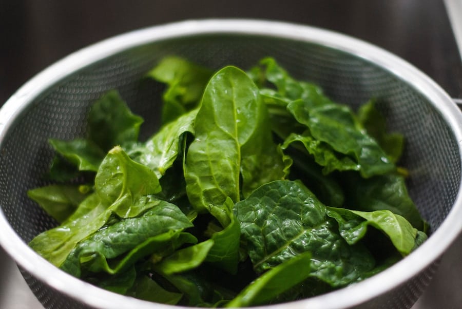 Colander with fresh spinach. 