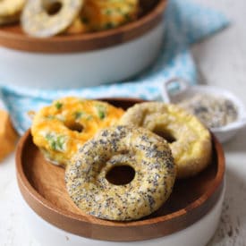 Keto everything bagel, jalepeno cheddar and poppyseed bagels on a wooden plate.