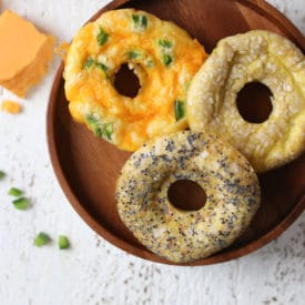 Keto everything bagel, jalepeno cheddar and poppyseed bagels on a wooden plate.