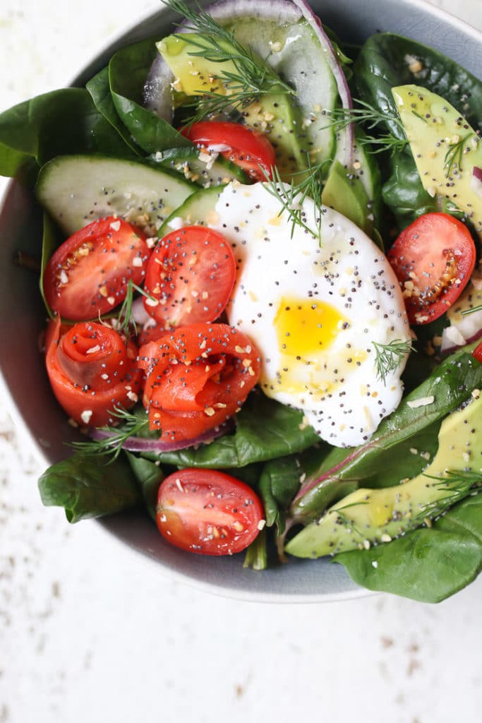 Keto salad topped with poached egg, smoked salmon and avocadoes in a bowl.