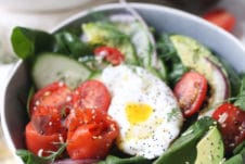 Keto salad topped with poached egg, smoked salmon and avocadoes in a bowl.