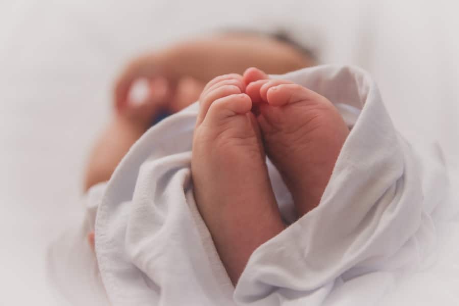 Baby's feet wrapped in a white blanket.