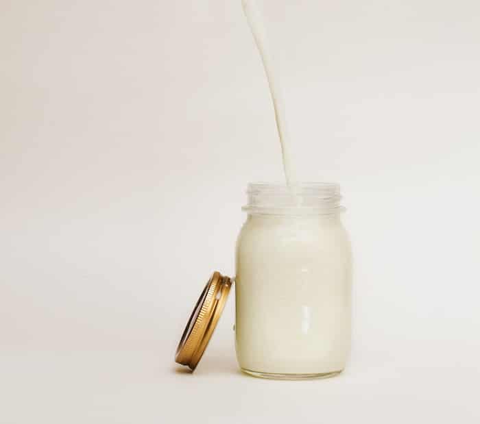 Milk being poured in a mason jar.