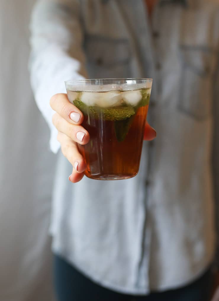 Person holding a glass of a healthy red hydrating low sugar drink