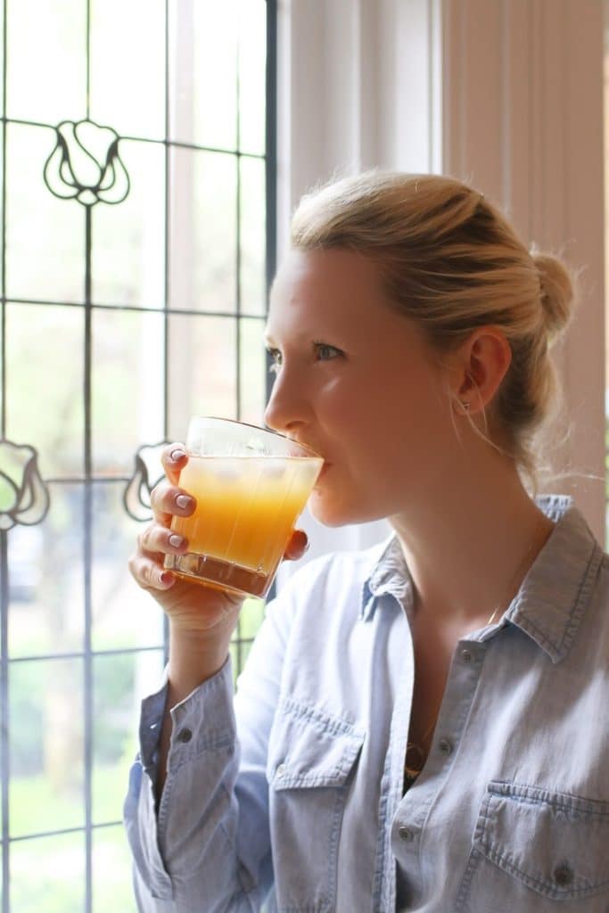 Woman drinking a glass of a healthy hydrating low sugar drink.