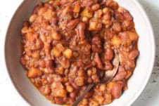 Close up of baked beans in a bowl with a spoon.