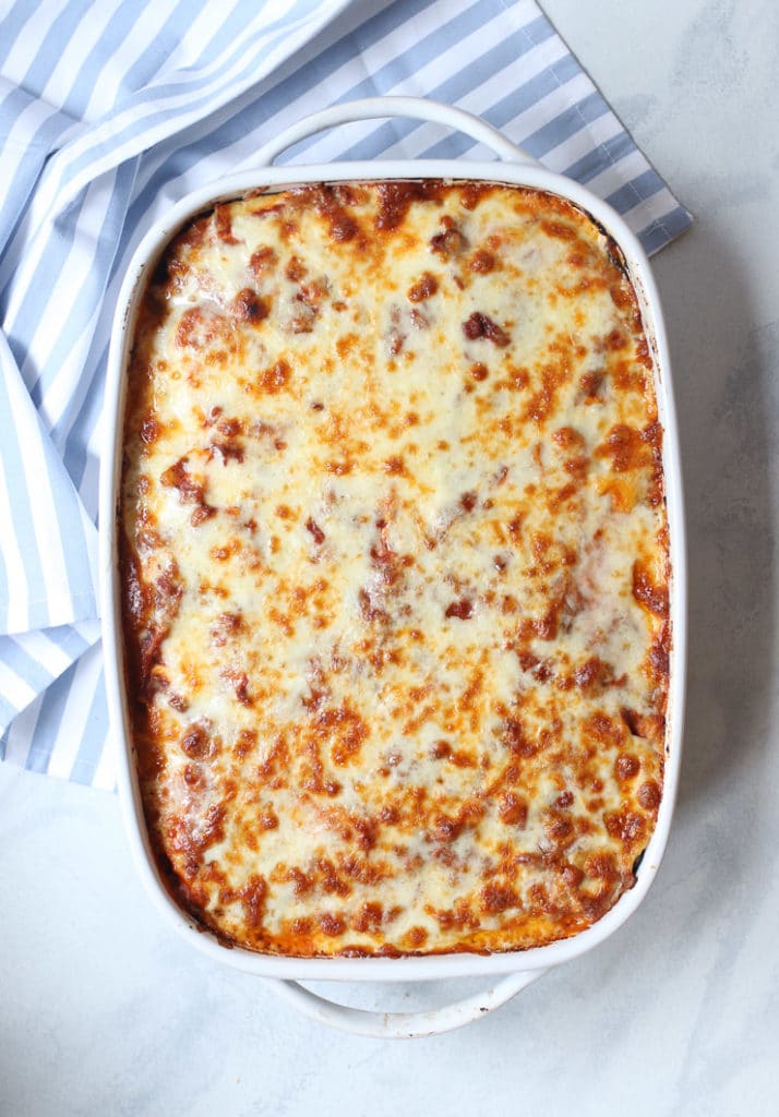 Cheesy Greek casserole in a white casserole dish. 