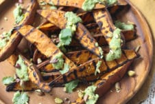 Plate with grilled sweet potatoes recipe with avocado lime sauce.