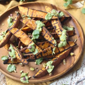 Plate with grilled sweet potatoes recipe with avocado lime sauce.