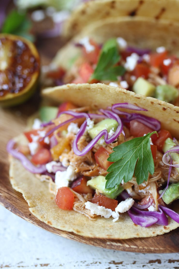 Pulled chicken tacos topped with slaw and cilantro.