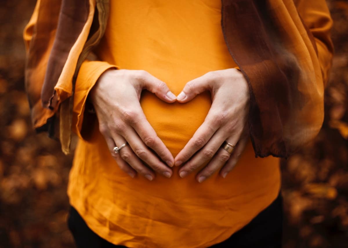 Person holding their hands over their stomach