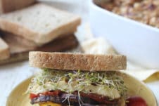 Veggie sandwich with hummus and halloumi served on a yellow plate.