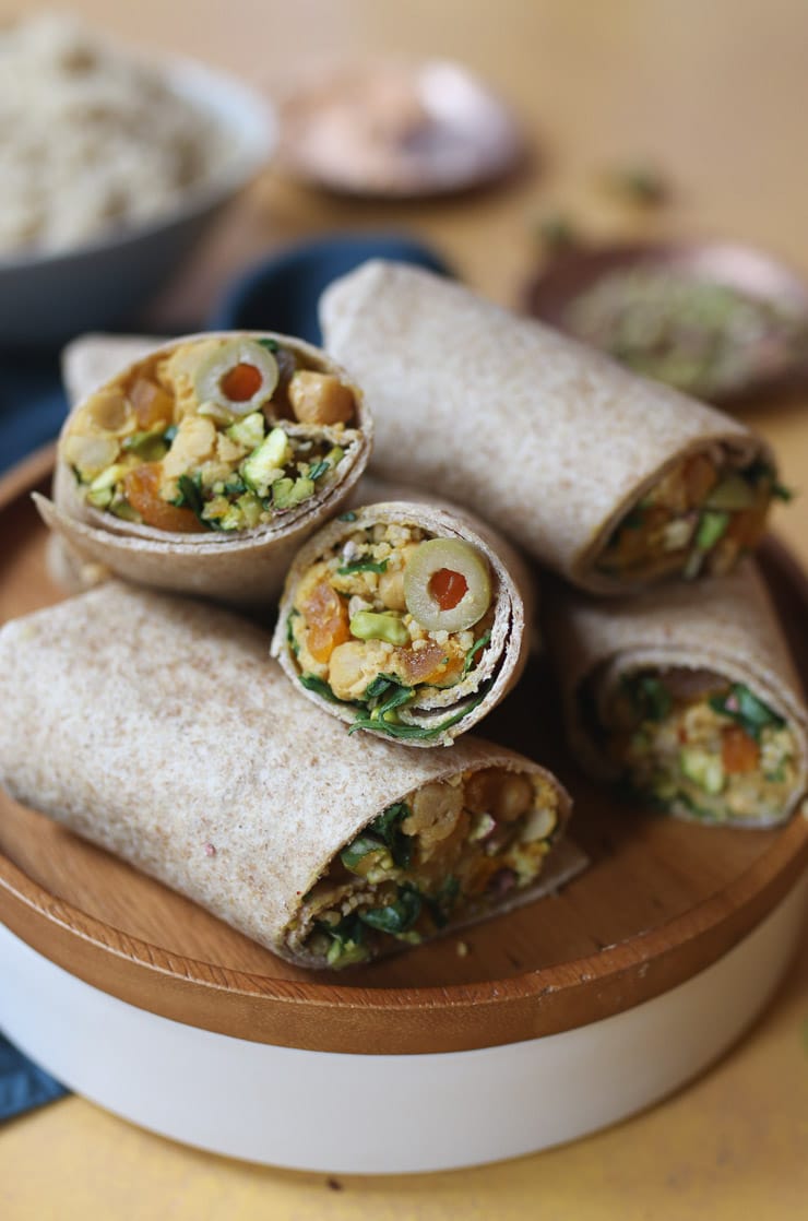 Moroccan chickpea salad wraps served on a wooden plate.