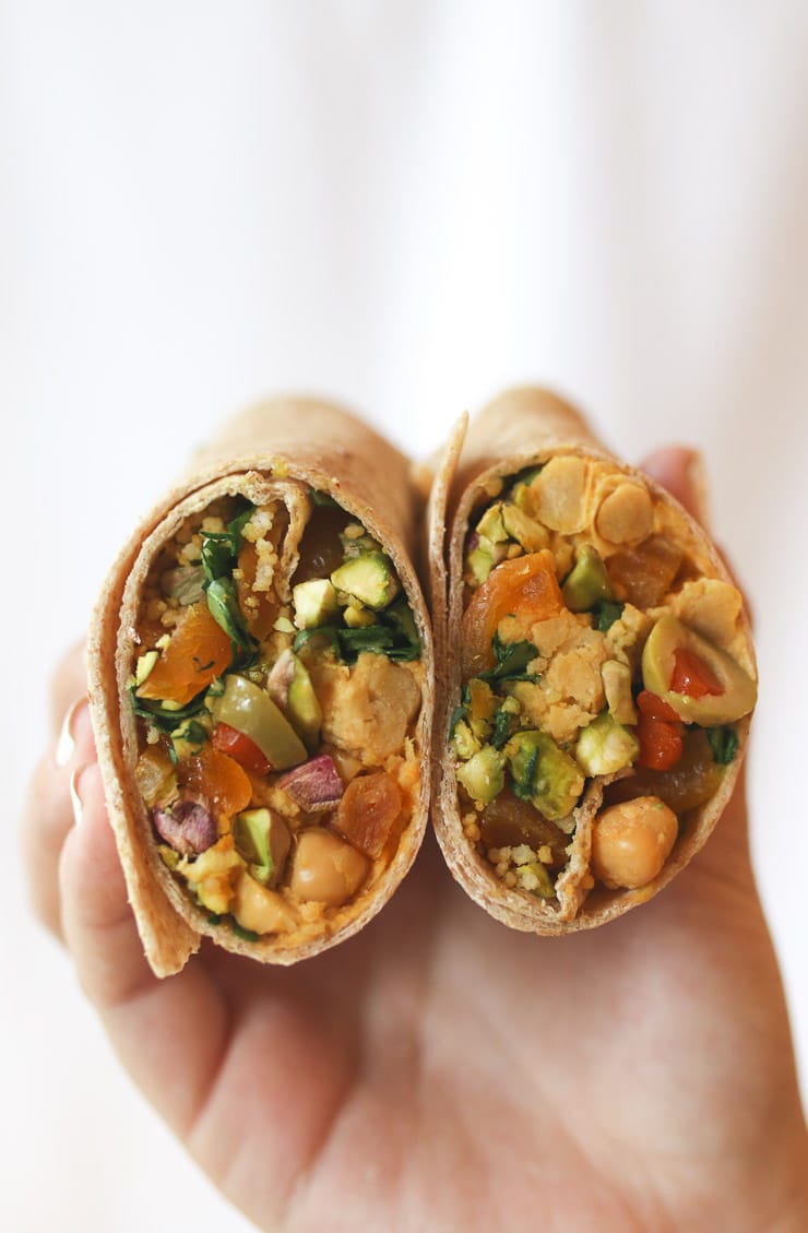 Hands holding moroccan chickpea salad wraps