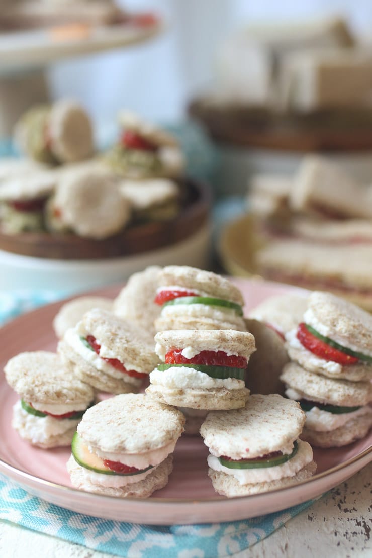 Strawberry and cucumber finger sandwiche on a pink plate.