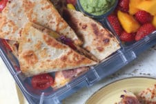 Quesadilla in a lunch box and served on a yellow plate.