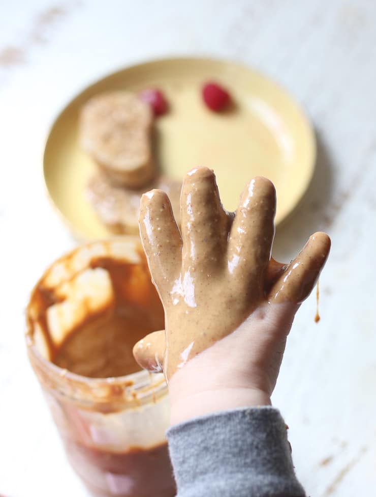 Baby's hand covered in peanut butter