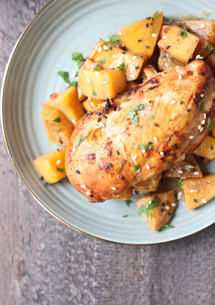 One pot fruity chicken breast on grey plate garnished with seeds and herbs