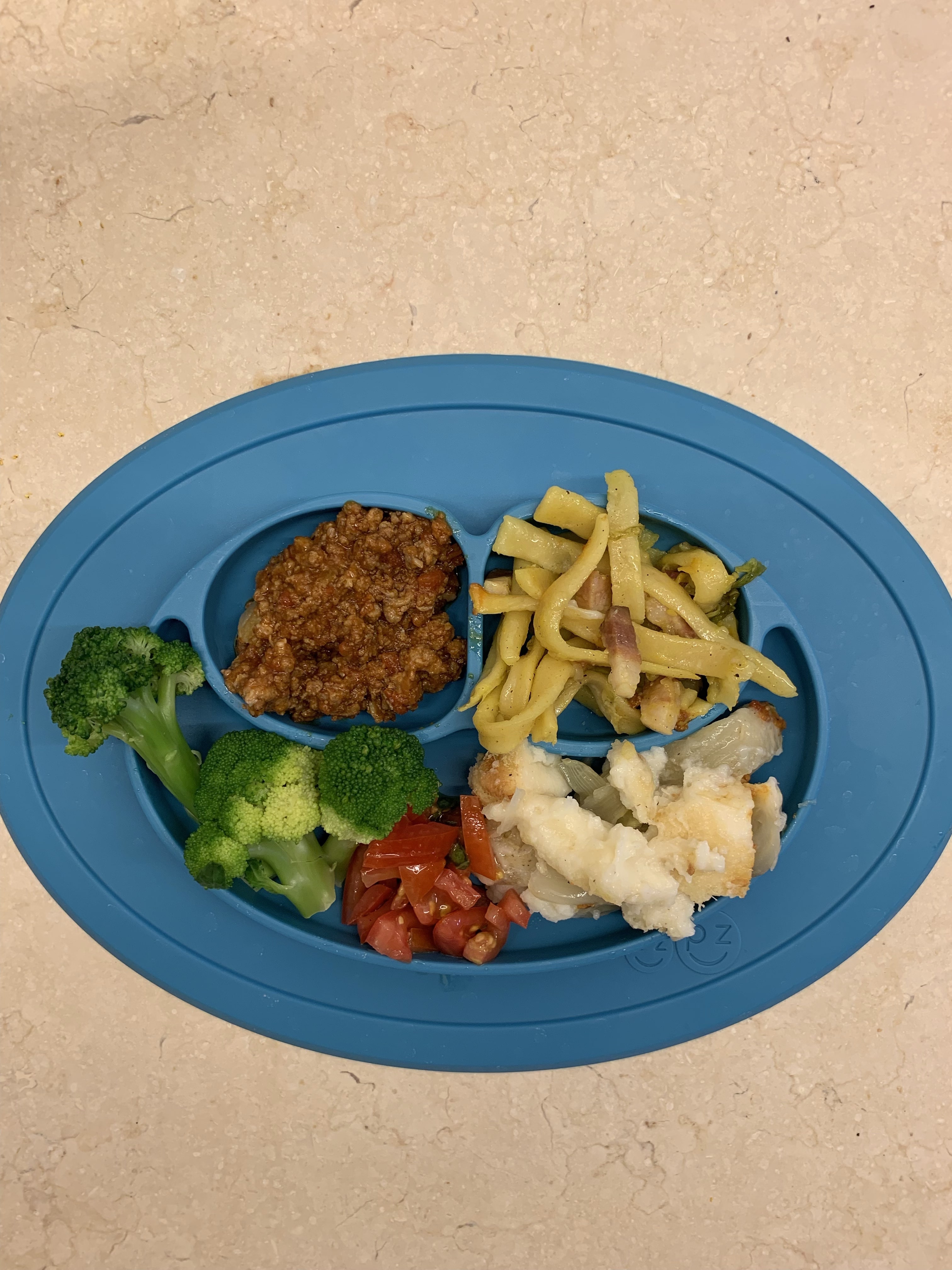 Toddler plate filled with pasta and vegetables. 