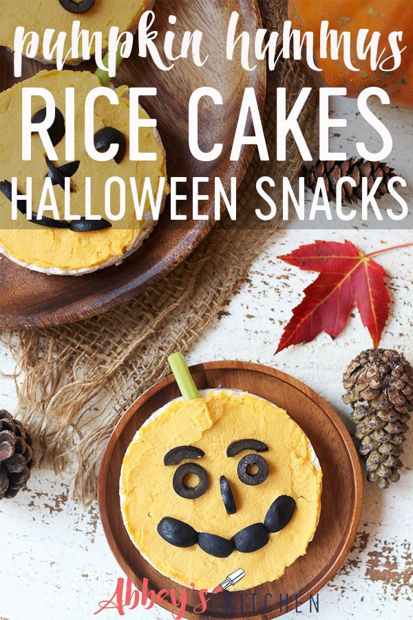 Pinterest image of two rice cakes topped with hummus on wooden plate with text overlay