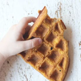 Toddler holding waffle.